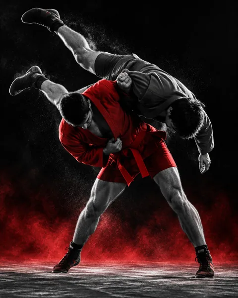 Luchador de sambo con chaqueta roja y botas de sambo proyectando a su rival en el tapiz