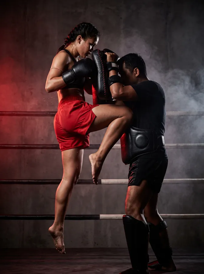 Deportista de muay thai golpeando los paos