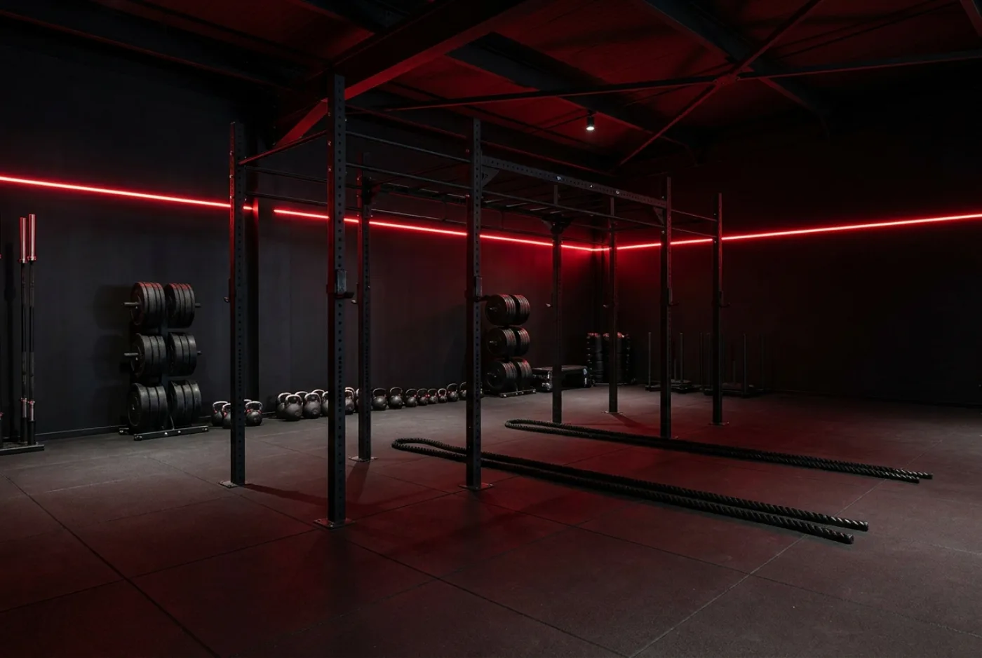 Zona de fuerza con racks, discos, kettlebells y cuerdas