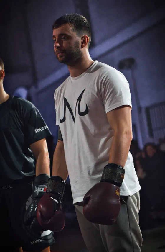 Deportista con guantes preparado para combatir en el dojo arena