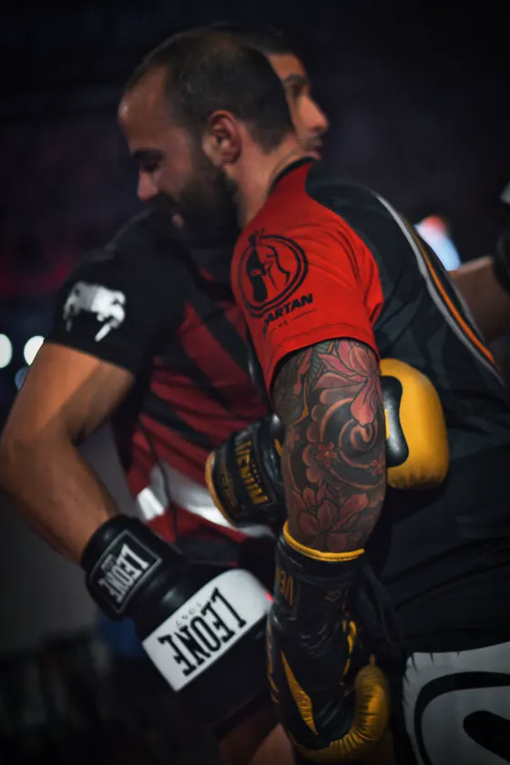 Detalle de un guante y un brazo tatuado durante un combate