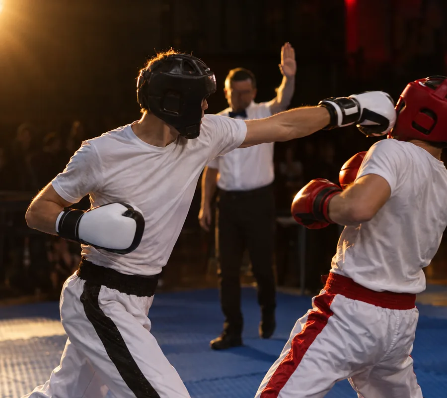 Point fighting en el tatami: puñetazo recto y el árbitro detiene la acción para puntuar