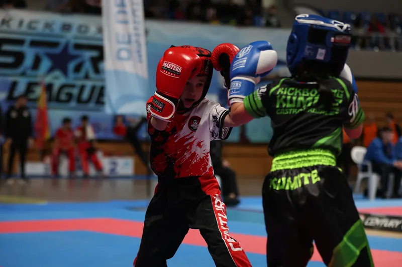 Dos competidores con casco intercambian golpes en el tatami de la kickboxing stars league en santander