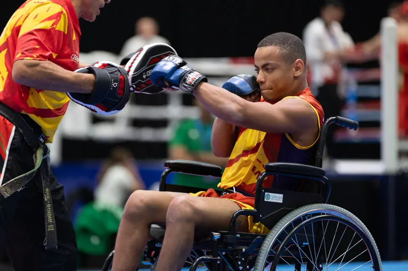 Deportista de parakickboxing de la selección española golpea las manoplas desde su silla en el mundial de abu dabi