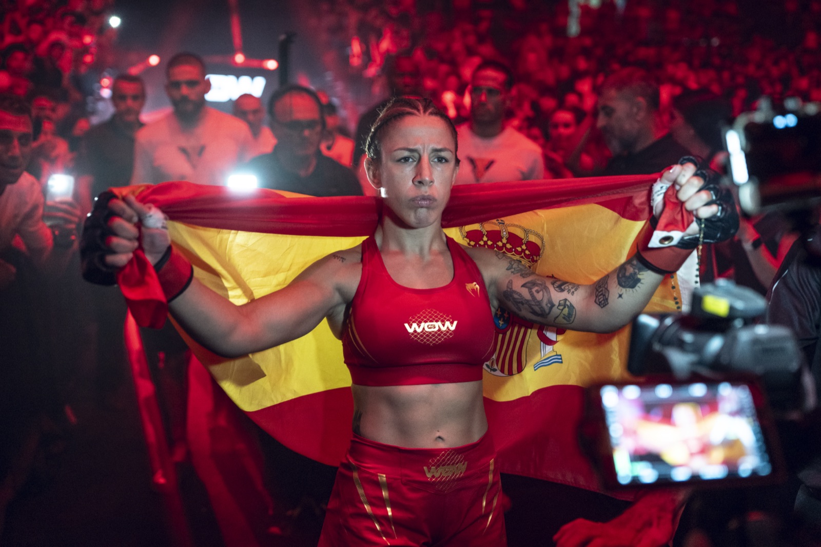 Sara viéitez con la bandera de españa tras ganar el cinturón del peso paja en wow 32 sevilla